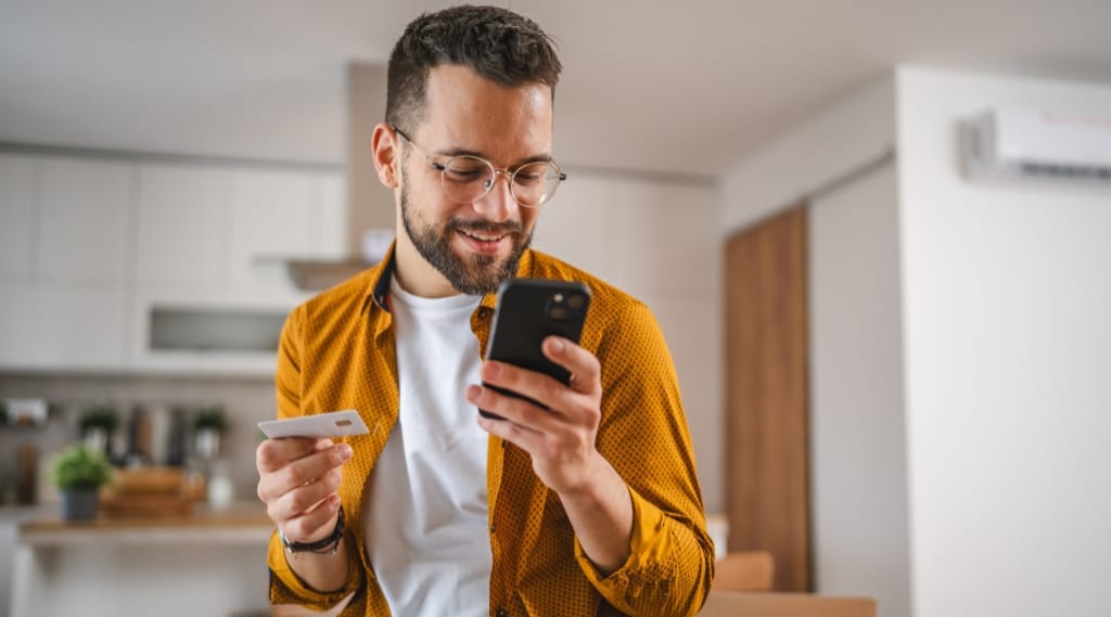 A man makes an e-commerce purchase on his mobile phone