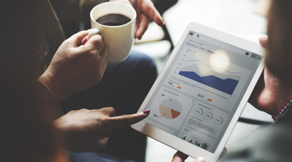 A marketing agency shows a client analytics and ROI data on a tablet