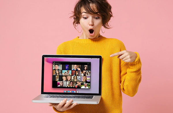 Woman pointing at the laptop screen where a Facebook Messenger Rooms call is ongoing